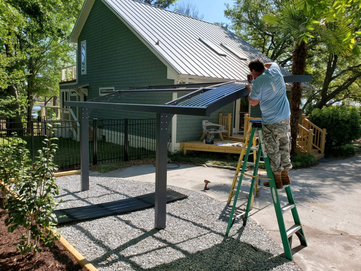 A man on a ladder working on the roof of a house.