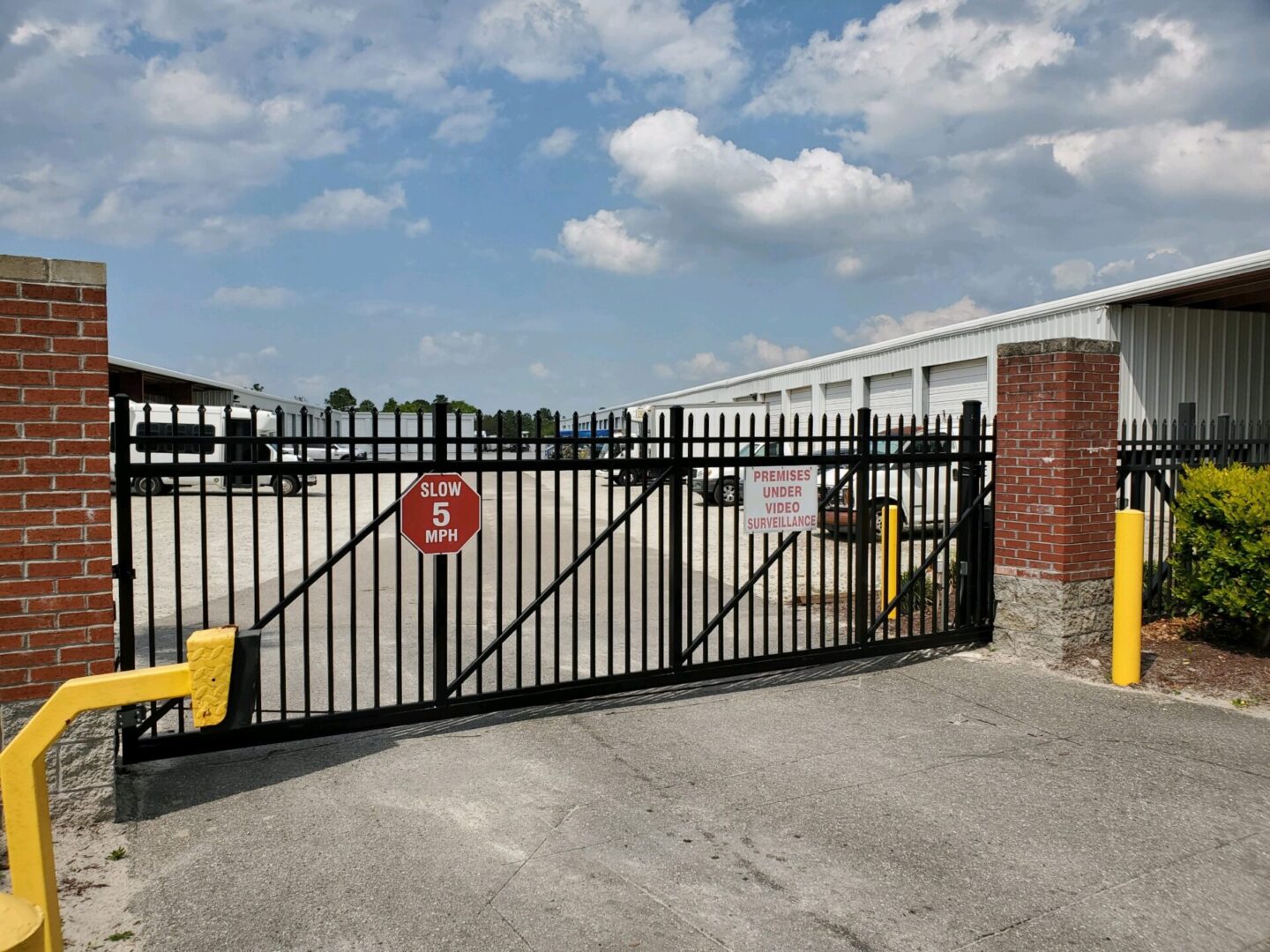 A gated parking lot with a fire hydrant and a fence.