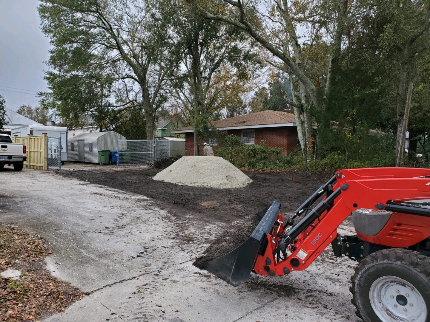 A red tractor is parked on the side of a road.